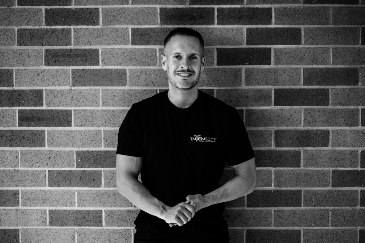 Black and white image of Alex Bastianon in a black shirt with hands clasped together