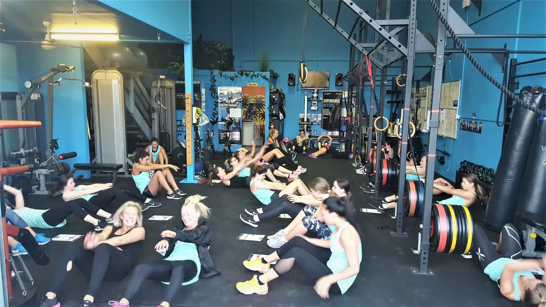 A large group of middle-aged women and kids doing a work out in Alex Bastianon's gym